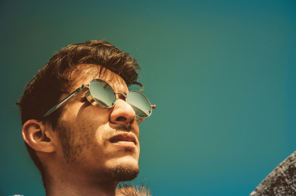 pexels-photo-343717-343717 Portrait of a man in sunglasses gazing upward on a clear sunny day.